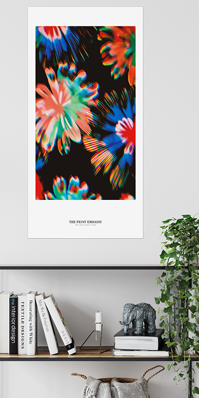 An oversized poster with a colorful abstract floral print on a black background with 'The Print Embassy' branding, placed above a shelf with books and decor.