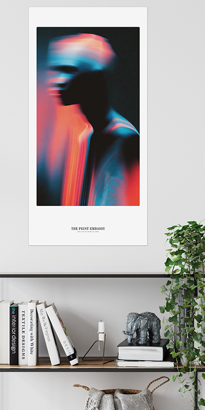 Framed abstract large art print on a wall above a bookshelf with decorative items.