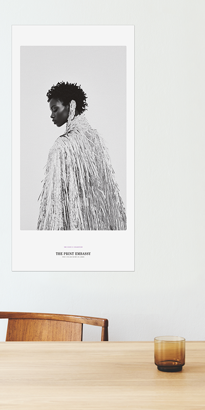 Framed black and white portrait of a person on a wall above a wooden table.