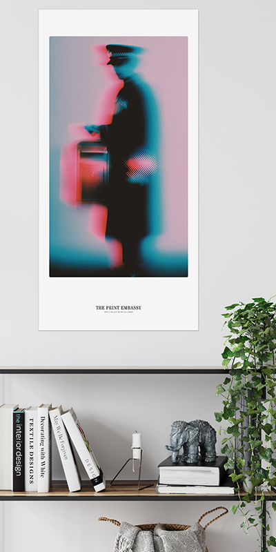 Framed abstract art print on a wall above a shelf with books and decor.